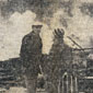 Valerie's grandfather with a customer. The smoldering remains of their shop can be seen in the background