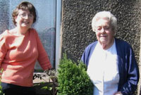 Y Cynghorydd Sheila Dafis yn cyflwyno twb o flodau a phlanhigion i Winnie Davies