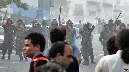 Supporters of opposition leader Mir Hossien Mousavi set fire to a barricade as they hurl stones at riot police during a protest in Tehran on Saturday June, 20, 2009