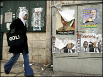 Femeie trecând pe lângă un afiş electoral în Ierusalimul de Est