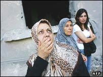 Mulheres olham espantadas para destruição