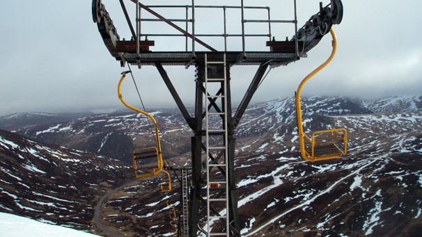 Ski lift chairs against mountain backdrop