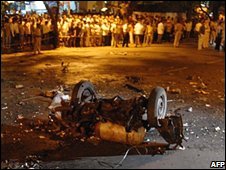 Người dân nhìn xe bị phá tối 26/11/2008 ở Mumbai