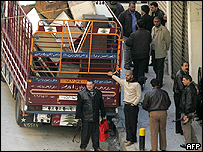 Agentes sírios carregam equipamentos em caminhão