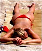 A woman sunbathing on a beach