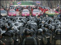 Cảnh sát chống bạo loạn đứng trước người biểu tình áo đỏ