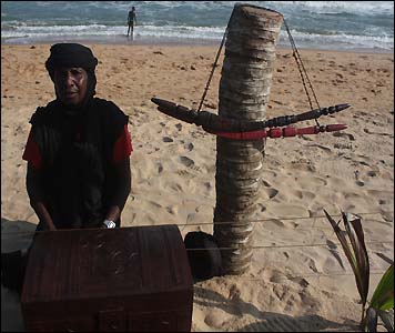 A trader sells handicrafts on the beach in Grand-Bassam