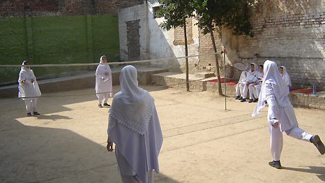 Girls wearing white and playing badminton