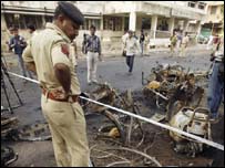 धमाकों के बाद जायज़ा लेता पुलिसकर्मी