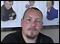 Man with goatee, background pictures of children