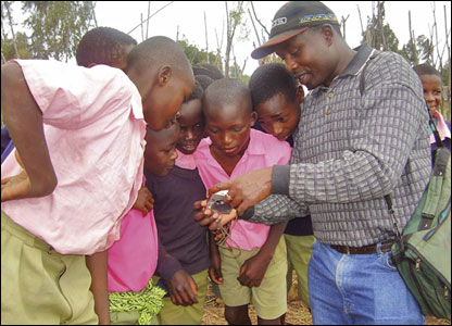 children crowd around for view of digital camera