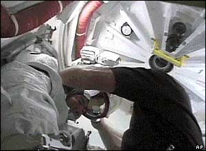 Astronauti se připravují na výstup do vesmírného prostoru (snímky NASA TV)