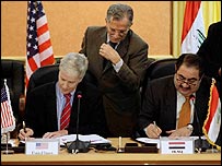 Aides to U.S. Ambassador to Iraq, Ryan Crocker, second from left, and Iraqi Foreign Minister Hoshyar Zebari, second from right, are on hand during a signing ceremony for a security pact between the United States and Iraq in Baghdad on Monday, Nov. 17, 200