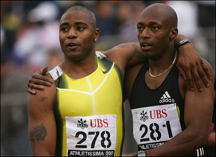 Marlon Devonish (R) is congratulated by Great Britain teammate Mark Lewis-Francis after winning the men's 100m