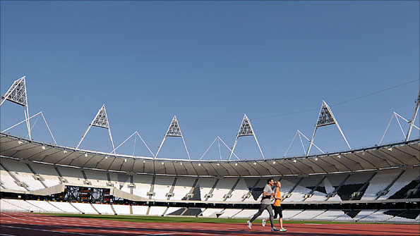 Lord Coe and Hannah England run round track at Olympic Stadium