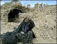 Iranian women sitting in debris