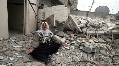 Một phụ nữ Palestine ngồi trên đống đổ nát của ngôi nhà mới bị đánh bom