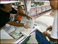 Simpatizante de Chávez mostra a pedestre como votar, em Caracas