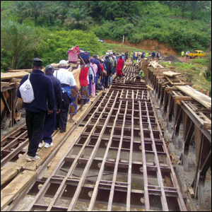 CamePassengers cross a bridge undergoing repairs over the river Mezam to board another vehicle on the other side.