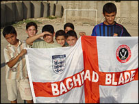 Iraqi children hold a Blades England flag