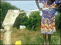 Menina africana tirando água de um poço rudimentar