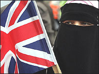 Peçeli bir Müslüman kadın bayrak tutuyor