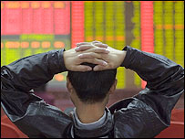 Investidor observa índices na bolsa de Pequim