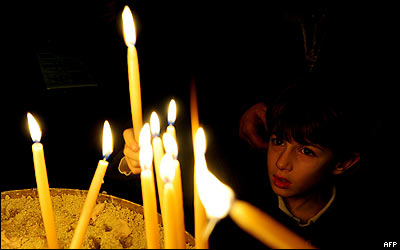 Un niño enciende velas