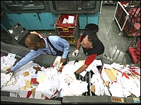 Postal workers sorting mail