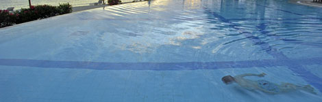 A man swimming underwater in a swimming pool