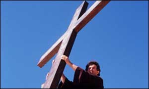 A man helping put up a cross