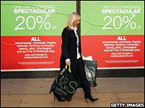 Woman walks past shop sale sign