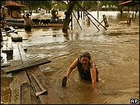 زنی راهش را در میان سیلاب جستجو می کند