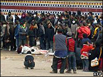 अबा में प्रदर्शनकारियों के शव के पास खड़े लोग