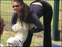 Mulher pratica ioga com seu cão