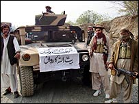 Taleban militanları ele geçirdikleri bir zırhlı araç ile