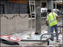Bir görevli çatışmalar sonrası olay yerini temizliyor