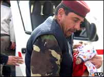 Soldado iraquiano leva criança ferida para hospital em Baquba