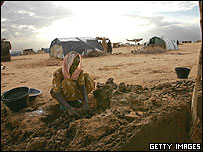 يک زن آواره سودانی در حال خشت زدن