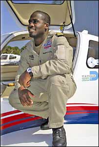 Barrington Irving Junior sitting on the wing of his plane
