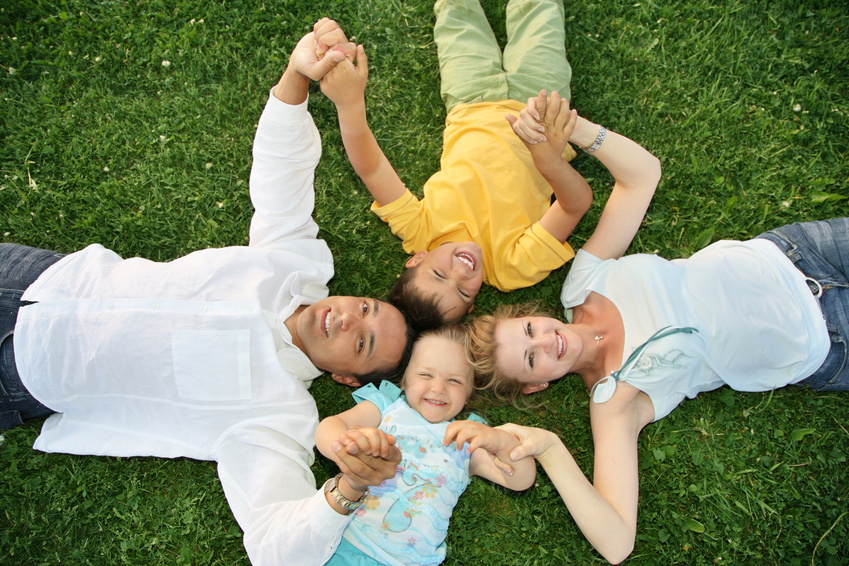 Family lying on grass @ Edyta Pawlowska - Fotolia.com