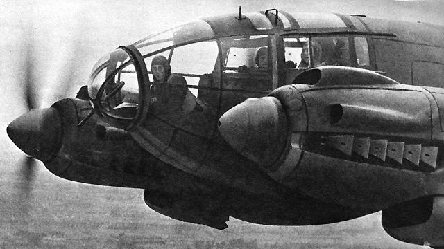 The aircrew of a Heinkel 111 bomber look out on accompanying plane, circa 1940.