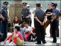 Çin'de Tiananmen meydanında başlarında polislerin beklediği göstericiler