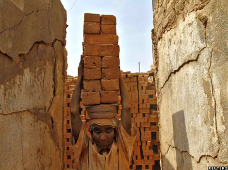 A woman carries bricks on her head in India