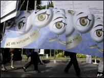 Membros de delegações passam atrás de cartazes na conferência da ONU sobre Mudança Climática, em Bali