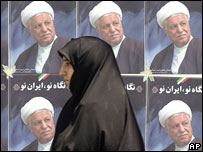 Mulher passa em frente a cartazes de Rafsanjani