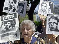 İşkence kurbanlarının fotoğrafını taşıyan kadın