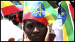 Young Ethiopian uses the national flag to shelter from the sun