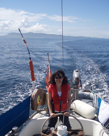 Photo of woman helming a yacht in Scotland