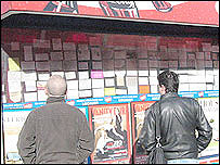 Imigrantes lêem anúncios em Londres